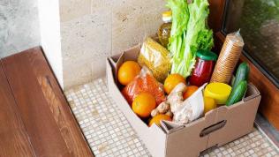 Photo of a cardboard box of food on someone's doorstep