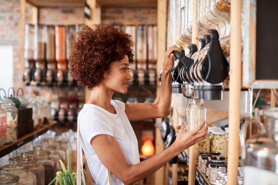 Woman refilling a jar of food in shop