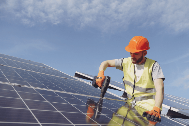 Worker fitting a solar panel to a roof
