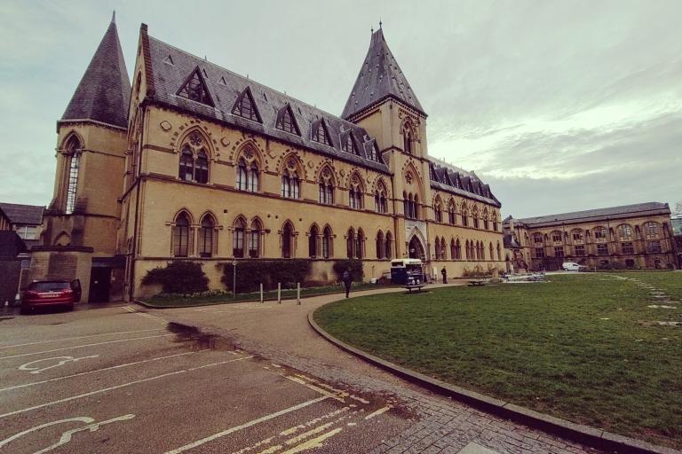 The sandstone Natural History Museum from the front lawn against a cloudy sky