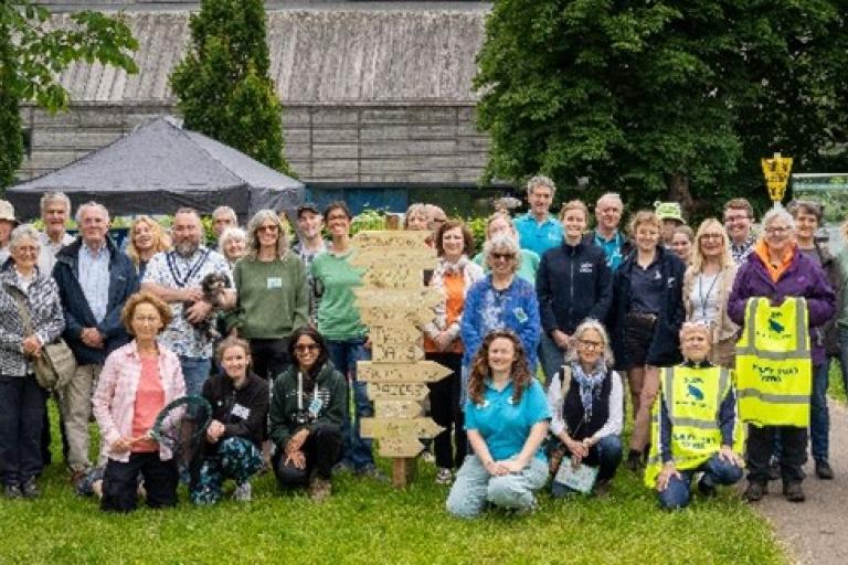 A large group of people stand in front of the camera.