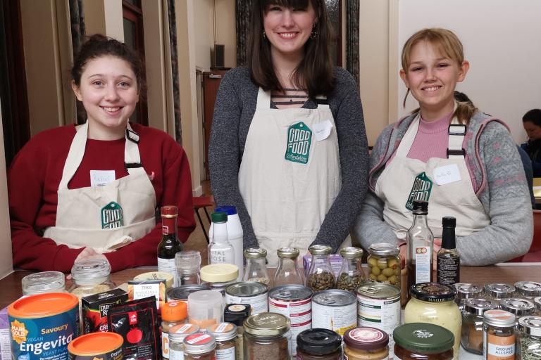 3 volunteers wearing aprons at a Good Food Oxfordshire cooking event.